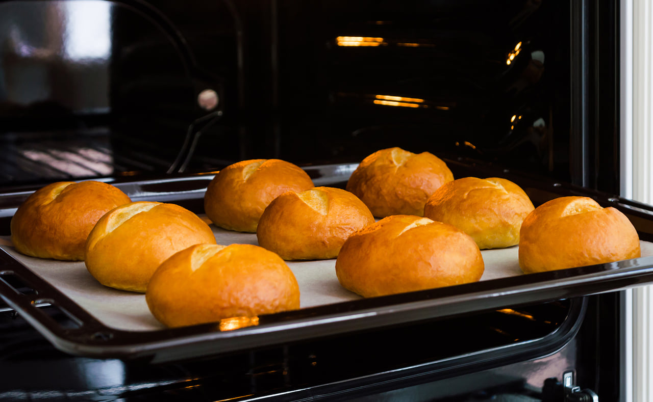 Freshly baked bread rolls in an oven.
