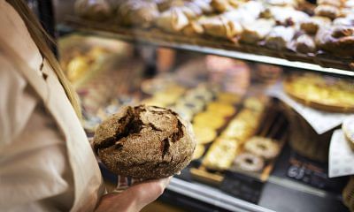 Person holding freshly baked round bread.